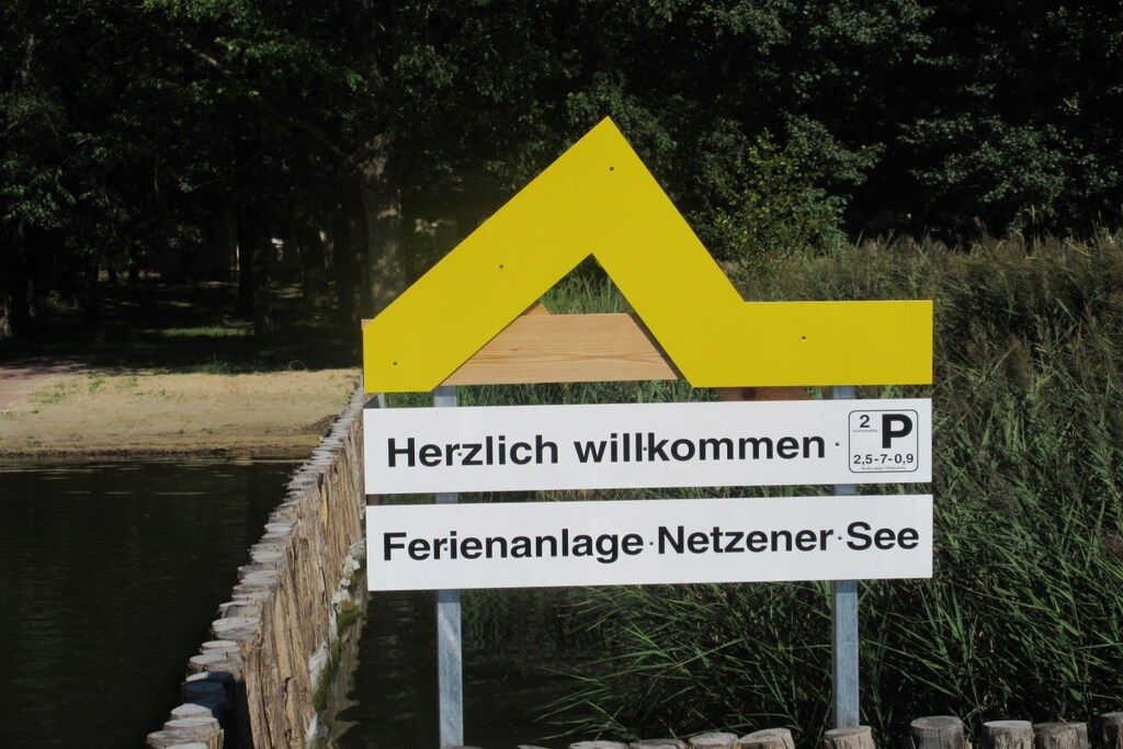 Een verwelkomingsbord met een gele pijl en een parkeersign met de cijfers 2-5-7-0-9.