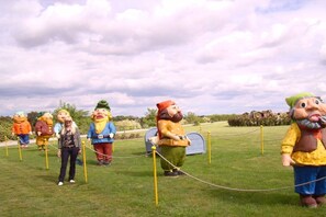 A group of large, colorful, cartoonish figures standing in a line on a grassy field. - Holiday home in Arendsee with swimming pool (Arendsee)