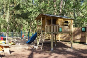 A wooden play structure with a slide and a small house-like building. - B 3 directly at Lake Netzen (Kloster Lehnin OT Trechwitz Siedling)