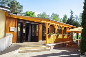 A wooden building with a covered patio area, outdoor seating, and a sign indicating it is a 'Schofferhofier.' - B 3 directly at Lake Netzen (Kloster Lehnin OT Trechwitz Siedling)