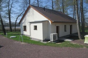 A small, single-story building with a sloped roof, a door, and a window, surrounded by trees and a gravel path. - B 3 directly at Lake Netzen (Kloster Lehnin OT Trechwitz Siedling)