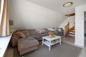Ein Wohnzimmer mit einer Couch, einem Couchtisch und einer Treppe.