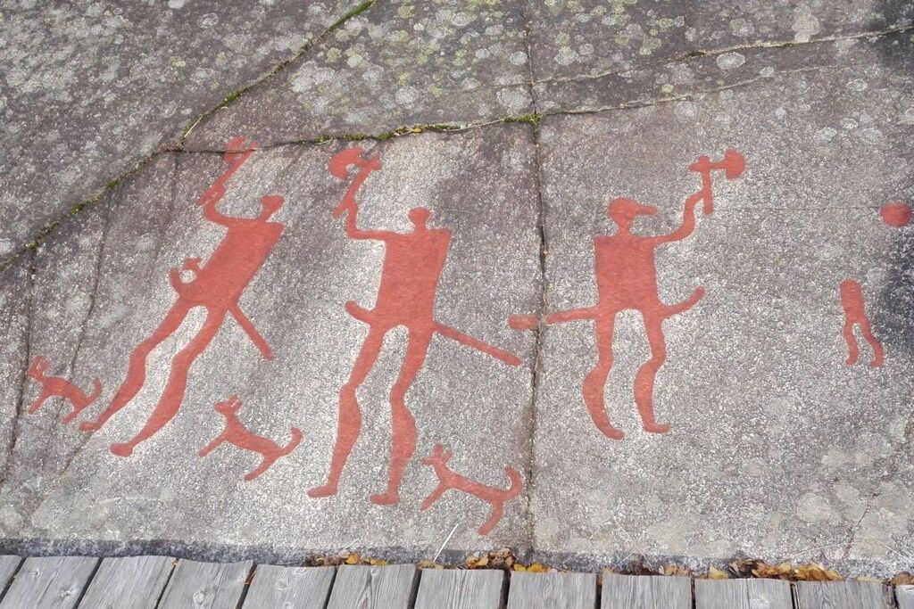Een betonnen oppervlak met rode graffiti afbeeldingen.