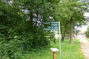 A directional signpost with multiple destinations listed, surrounded by lush greenery. - Holiday home with 1 bedroom (Visselhövede)