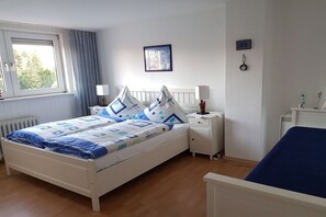 A bedroom with a bed, bedside tables, a window, and a view of the outdoors. - Holiday home with 1 bedroom (Visselhövede)