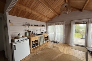 A rustic kitchen with wooden beams, a stove, and a sink. - Holiday home with 1 bedroom (Vinkeveen)