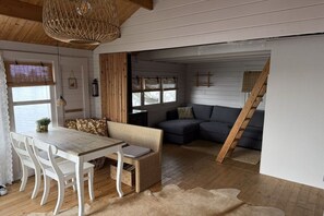 A cozy interior with a dining area, a sofa, and a staircase. - Holiday home with 1 bedroom (Vinkeveen)