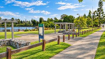 A park with a gazebo, a stone wall, a wooden fence, and a clear sky.
