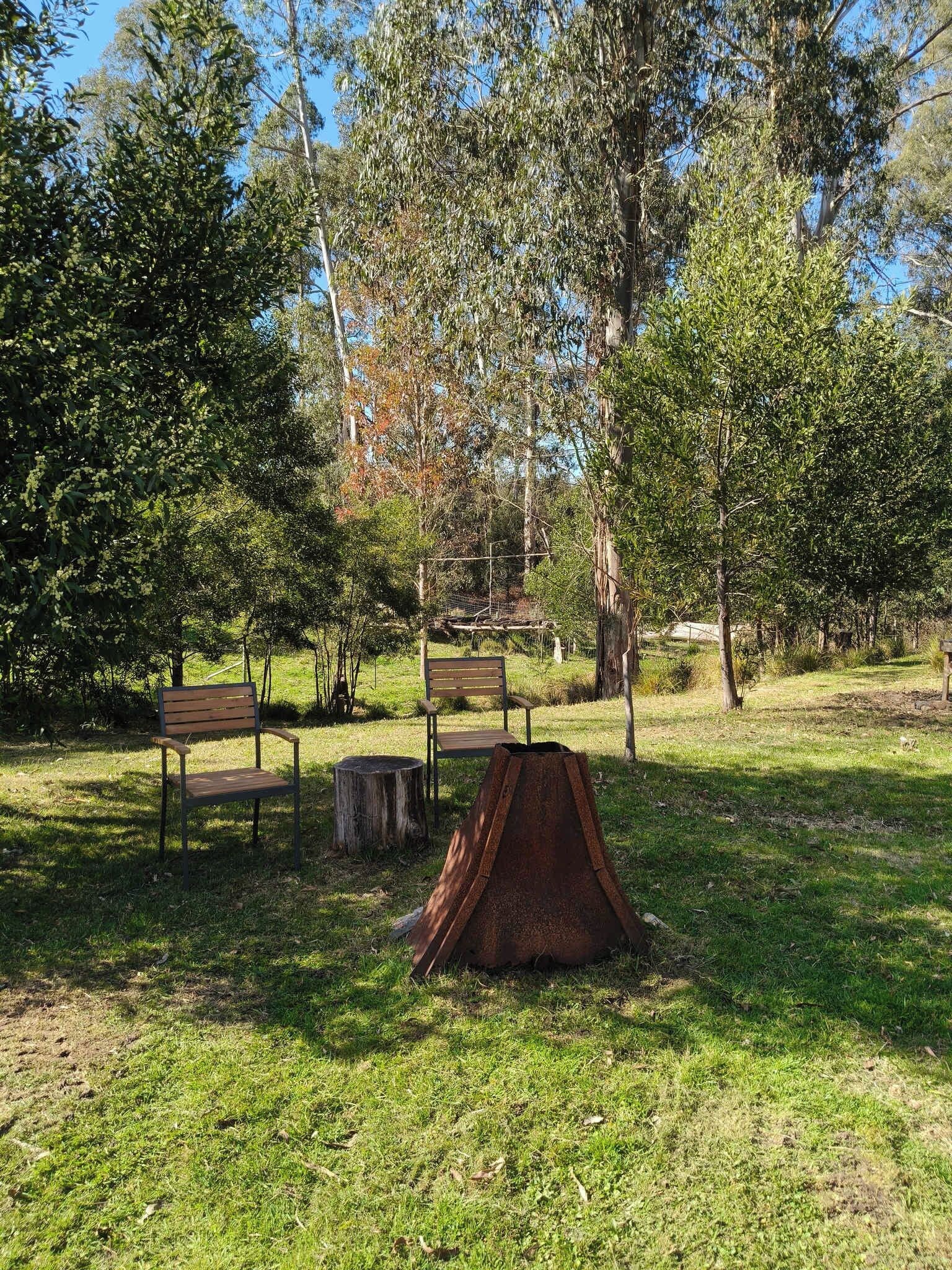 A park with benches and a rusted metal structure.