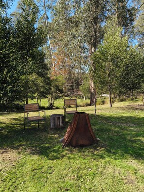 A park with benches and a rusted metal structure.