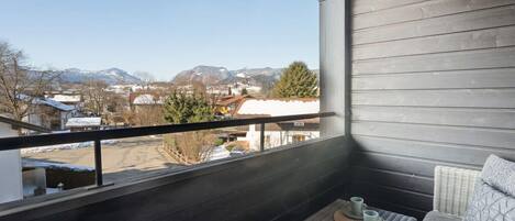 A balcony with a view of a snowy landscape and buildings.
