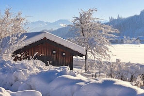 A wooden cabin surrounded by snow-covered trees and a clear sky. - Holiday apartment in Oberstdorf with balcony (Oberstdorf)