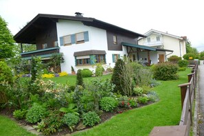 Ein zweistöckiges Haus mit einem Garten davor.