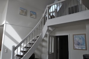 A staircase leading to an upper floor with a door at the bottom. - Holiday apartment with 1 bedroom (Krummhörn \/OT Greetsiel)