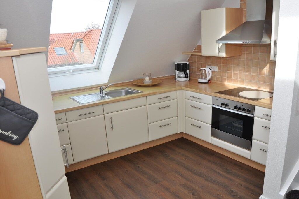 A modern kitchen with a skylight, a coffee maker, and a stove.