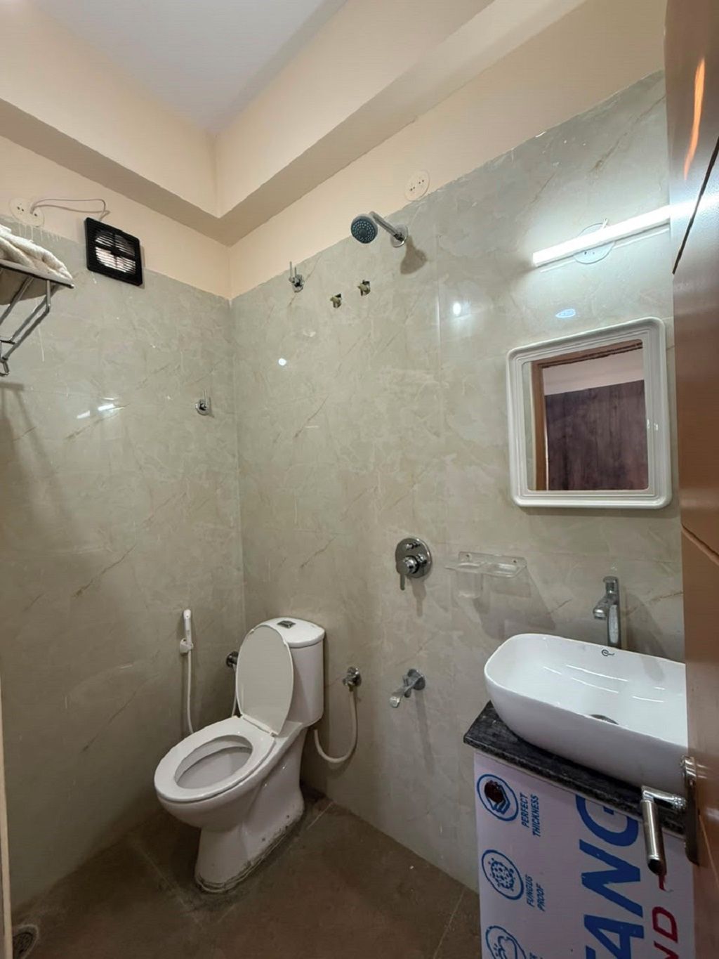 Un baño con inodoro, ducha y lavamanos.
