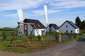 Ein Wohngebiet mit modernen Häusern, einer Schaukel und Wimpeln.