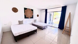 A room with two beds, a large window with curtains, and a wooden ladder. - Spacious 5-bedroom house in charming La Libertad with AC (La Libertad)