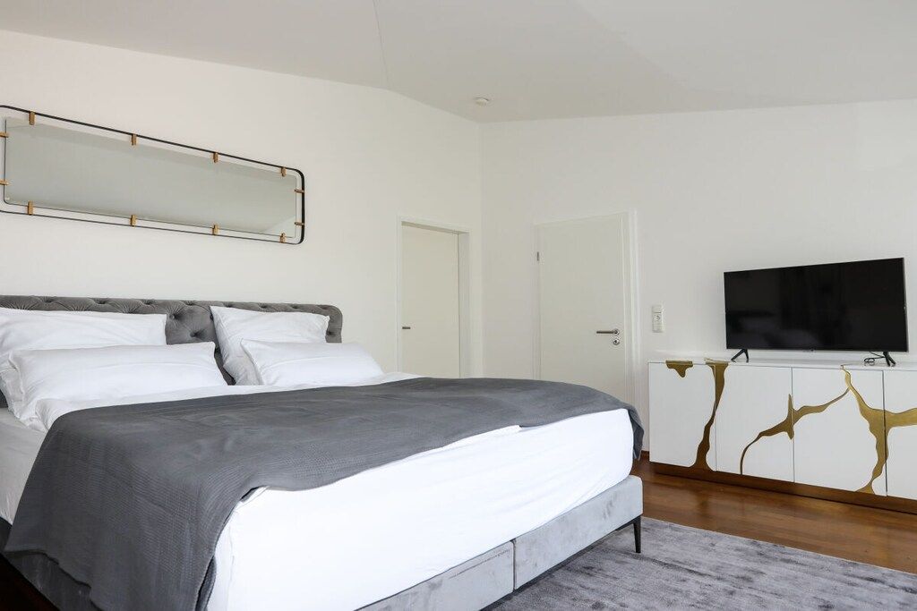 A bedroom with a bed, a television, and a cabinet.
