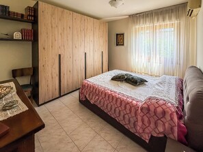 A bedroom with a bed, a wardrobe, a desk, and a chair. - Casa Armando (Passignano sul Trasimeno)