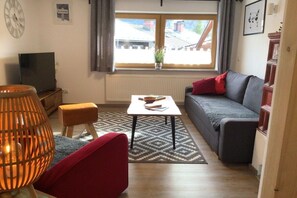 A living room with a sofa, a small table, a TV, and a lamp. - Holiday apartment with 1 bedroom (Bischofswiesen)