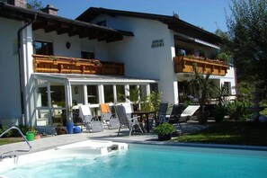 A hotel with a pool area, outdoor seating, and a balcony with plants. - Holiday apartment with 2 bedrooms (Bischofswiesen)