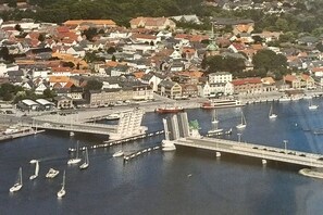 Een kustplaatsje met een jachthaven, een brug en gebouwen met traditionele architectuur.