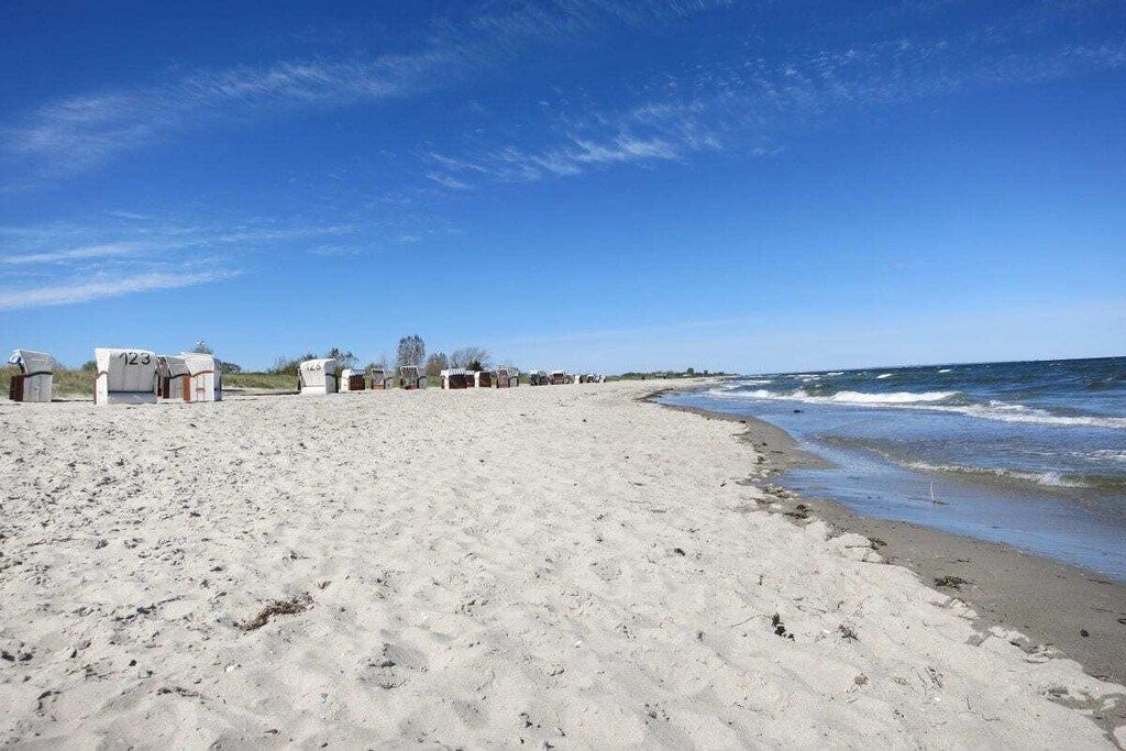 Une plage bordée d’une rangée de bâtiments.