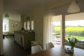 A kitchen with a dining area, a view of the garden, and a table with a vase. - Holiday home with 3 bedrooms (Kronsgaard)