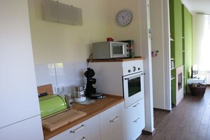 A kitchen with a microwave, coffee maker, and a clock on the wall. - Holiday home with 3 bedrooms (Kronsgaard)