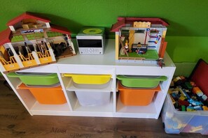 A white storage unit with multiple compartments, each containing colorful storage bins. - Holiday home in Hooksiel with swimming pool (Hooksiel)