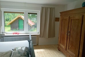 A room with a window, a radiator, a wooden wardrobe, and a bed. - Beach holiday at the "Kiebitz" (Bensersiel)