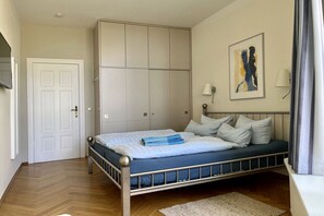Ein Schlafzimmer mit Bett, Kleiderschrank, Gemälde und Lampe.