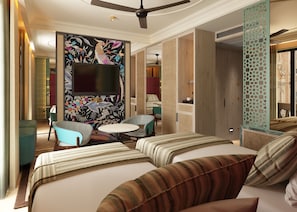 Een hotelkamer met een groot bed, een televisie, een klein rond tafeltje en twee fauteuils.