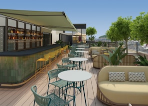 A rooftop bar with outdoor seating, including round tables and chairs, and a bar counter with bottles. - Hotel Fenix Sevilla by Vibra - New Opening 2027 (Seville)