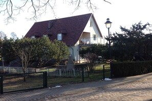 A two-story house with a red-tiled roof, a balcony, and a lamp post. - Holiday apartment with 1 bedroom (Zislow)