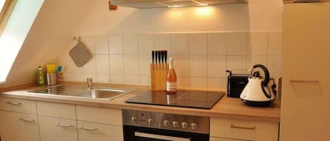 A kitchen with a stove, oven, and a microwave.
