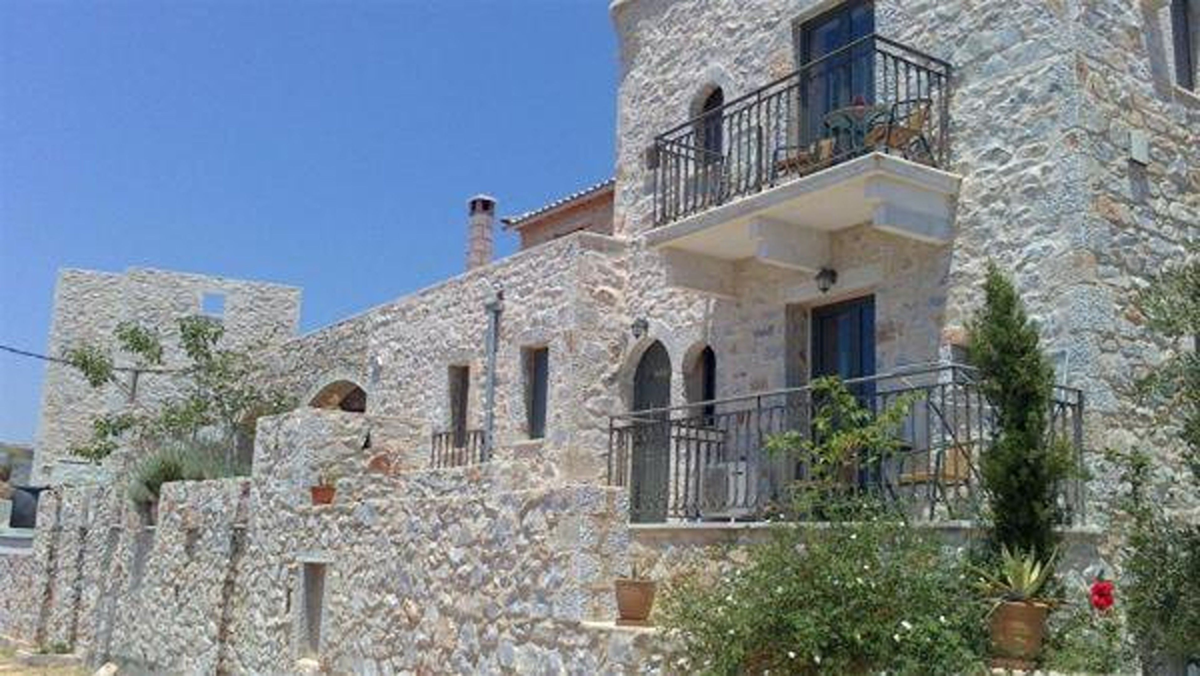 A stone building with multiple balconies and arched windows.