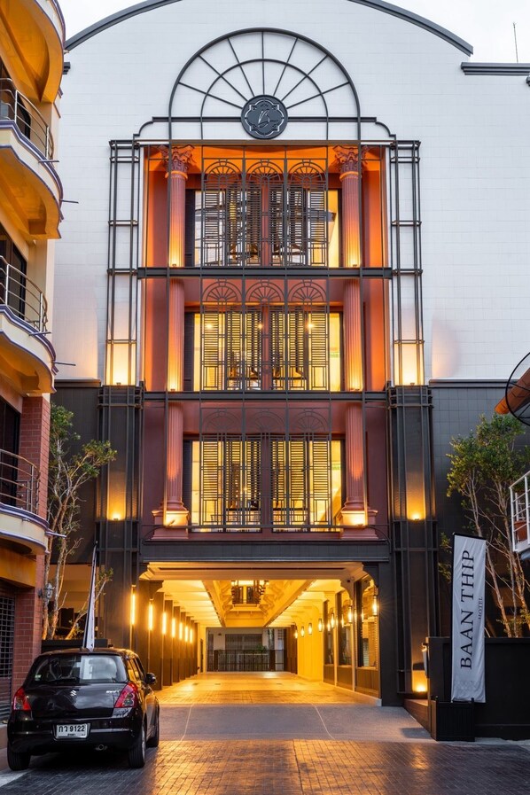 A hotel entrance with a grand archway, a clock, and a banner.