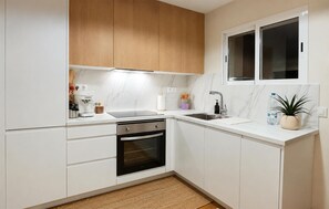 A modern kitchen with white cabinetry, a built-in oven, a sink, and a window above the countertop. - 2 bedroom stunning apartment in San Javier (San Javier)