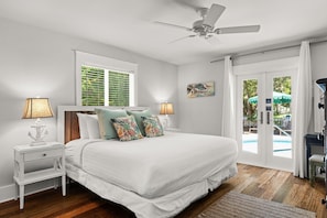 A bedroom with a bed, nightstands, a ceiling fan, and a view of the outdoors. - Welcome to Salty Palm 🌴<br>Escape to Salty Palm, a spacious 6-bedroom 30A beach retreatjust steps from the beautiful white-sand beaches and emerald waters of the Emerald Coast! (Inlet Beach)