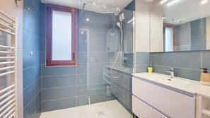 A modern bathroom with a glass shower enclosure, a white sink, and a mirror. - 2-CEVAA013 (Praz-sur-Arly)