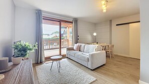 A modern living room with a sofa, a small round table, and a potted plant. - 2-CEVAA013 (Praz-sur-Arly)