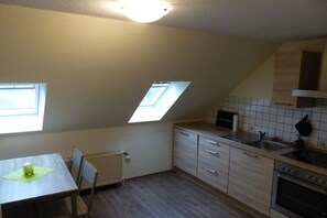 Eine kleine Küche mit einem Oberlicht, einem Esstisch und einer Heizung.