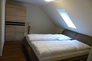 Une chambre à coucher avec un lit, une fenêtre et une armoire.