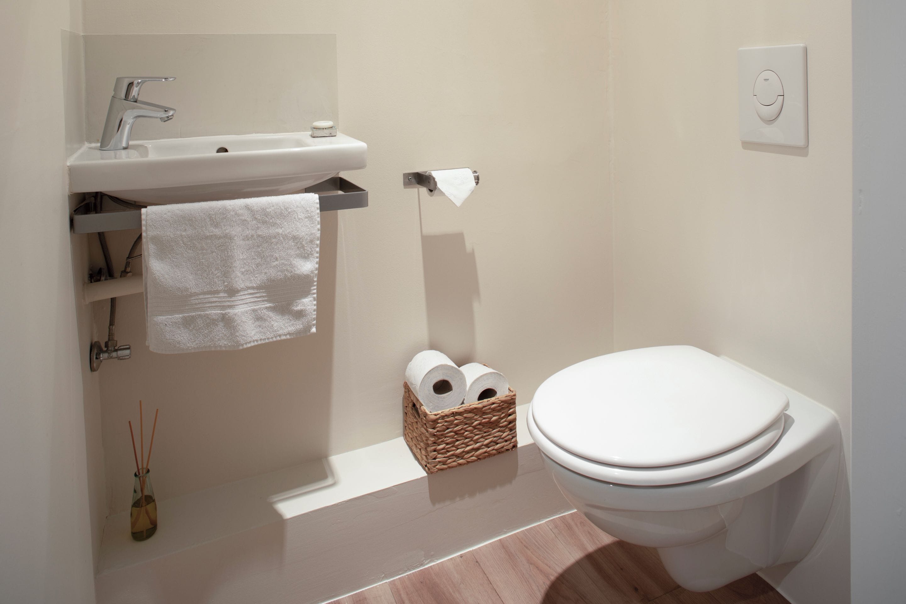 Une salle de bain équipée de toilettes, d’un lavabo et d’un porte-serviettes.