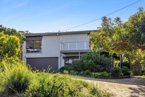 A modern two-story house with a garage, surrounded by lush greenery and trees. - Ocean View House Fairhaven (Fairhaven)