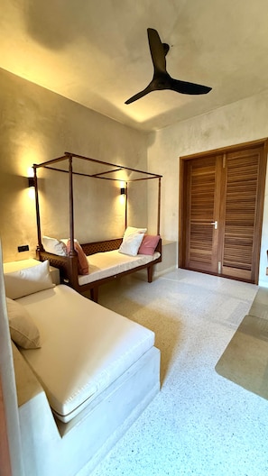 Ein Schlafzimmer mit zwei Betten, einem Holzschrank und einem Deckenventilator.