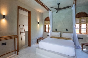 A bedroom with a bed, a ceiling fan, and two windows with curtains. - Waridi North | Breeze – 2BR Upper Floor (Diani Beach)