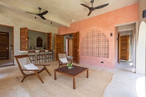 A spacious living area with a high ceiling, ceiling fans, a central coffee table, and wooden furniture. - Waridi North | Breeze – 2BR Upper Floor (Diani Beach)